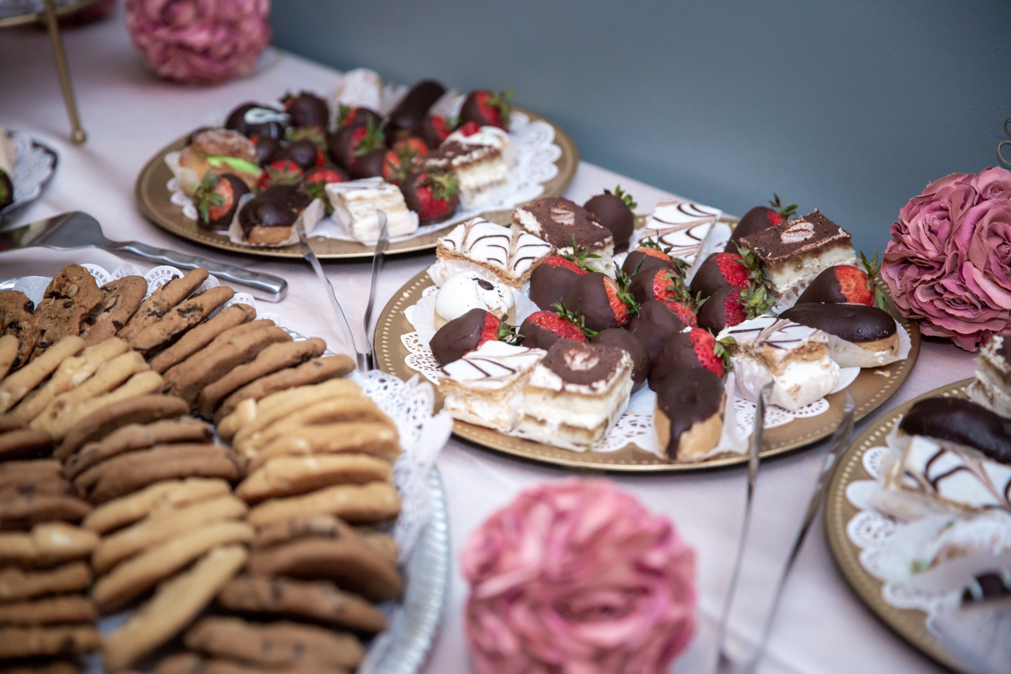Wedding dessert table with cookies, chocolate-covered strawberries, and assorted pastries
